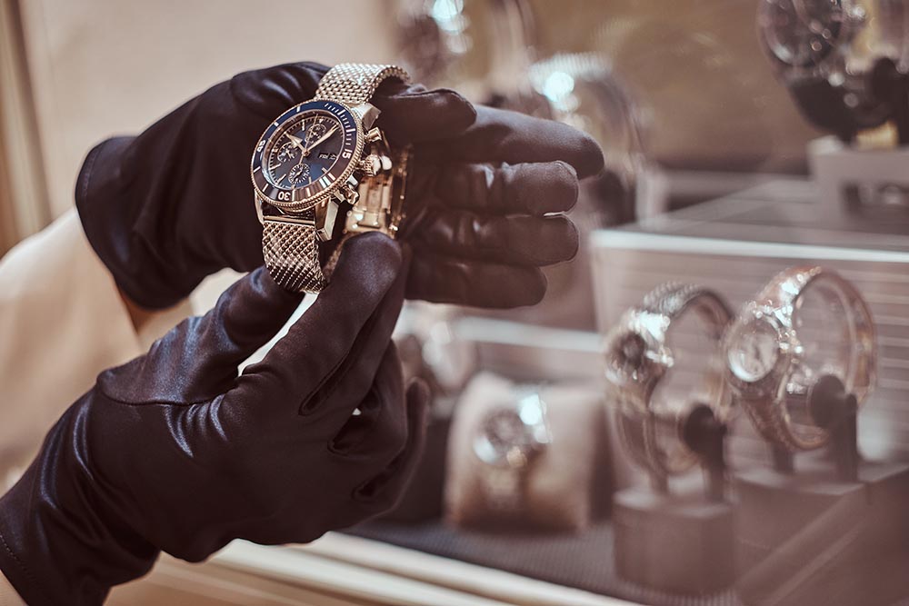 close up seller s hands gloves shows exclusive men s watch from new collection luxury jewelry store